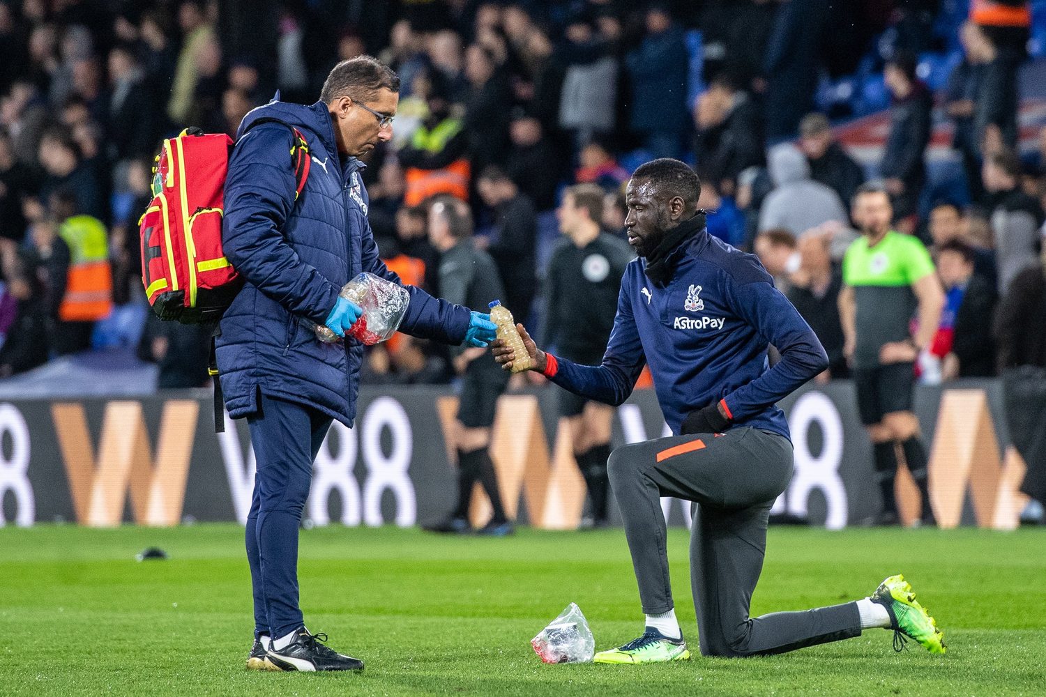 Dr Zaf hands Cheikhou Kouyaté a drink to break his fast on the pitch at Selhurst Park